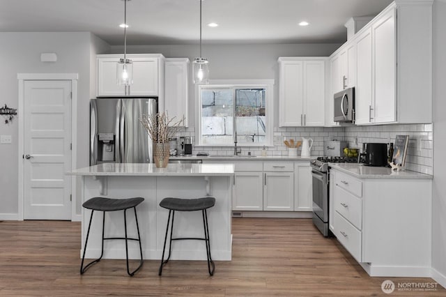 18207 Majestic Ridge Ln, Mount Vernon, WA 98274 - kitchen featuring appliances with stainless steel finishes, a breakfast bar, white cabinets, decorative backsplash, and recessed lighting