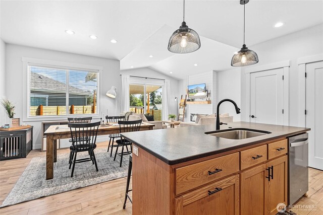 2183 Lagerwey Cir, Lynden, WA 98264 - kitchen featuring dark countertops, vaulted ceiling, an island with sink, recessed lighting, and light wood-style floors