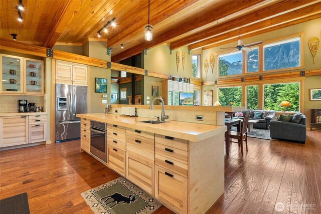 20720 501st Dr SE, Index, WA 98251 - kitchen with appliances with stainless steel finishes, light brown cabinetry, dark wood-style floors, a wood ceiling with exposed beams, and a high ceiling
