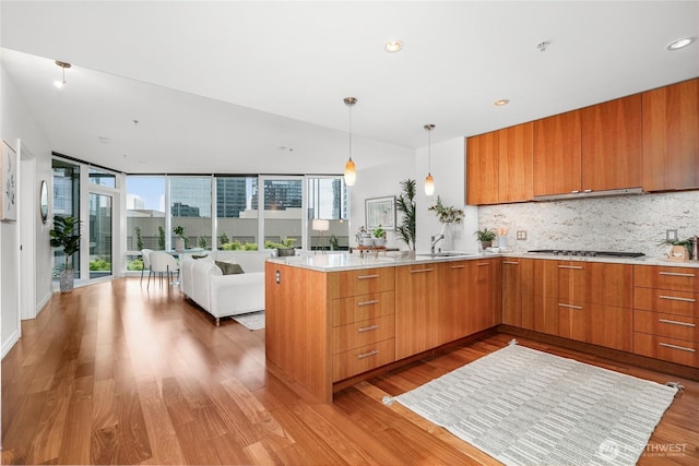 10700 NE 4th St Unit 806, Bellevue, WA 98004 - kitchen featuring open floor plan, plenty of natural light, backsplash, light wood-type flooring, and recessed lighting