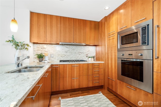 10700 NE 4th St Unit 806, Bellevue, WA 98004 - kitchen with stainless steel appliances, dark wood finished floors, light stone countertops, modern cabinets, and backsplash
