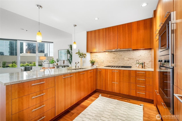 10700 NE 4th St Unit 806, Bellevue, WA 98004 - kitchen featuring appliances with stainless steel finishes, modern cabinets, light wood-type flooring, a peninsula, and tasteful backsplash