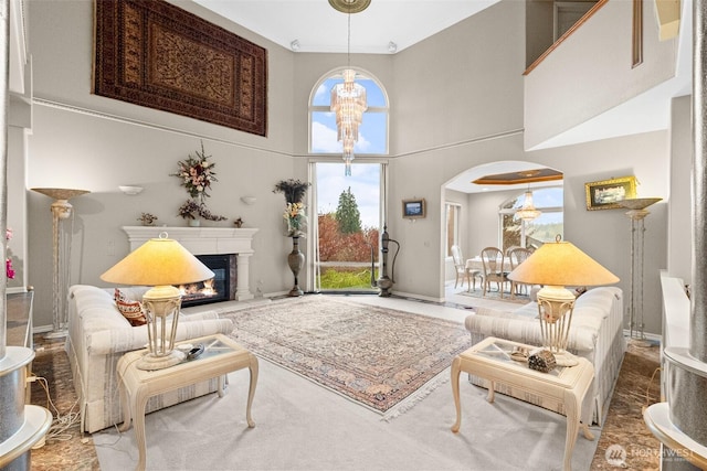 10316 NE 153rd Pl, Bothell, WA 98011 - living room featuring healthy amount of natural light, a high ceiling, a glass covered fireplace, arched walkways, and a chandelier