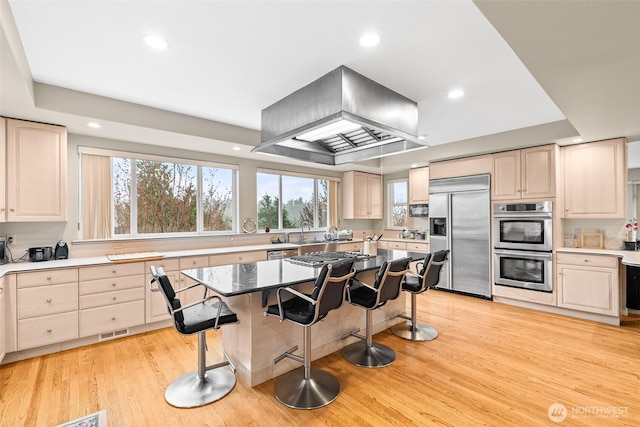 10316 NE 153rd Pl, Bothell, WA 98011 - kitchen featuring stainless steel appliances, range hood, a breakfast bar area, light wood-style floors, and recessed lighting
