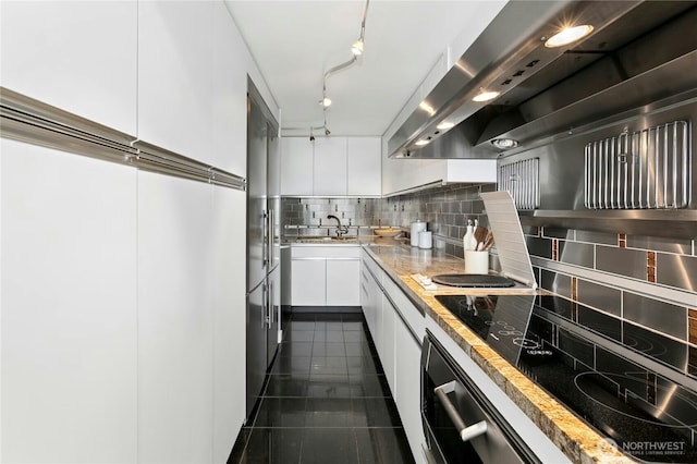 525 Belmont Ave E Unit 4F, Seattle, WA 98102 - kitchen featuring extractor fan, white cabinetry, decorative backsplash, dark tile patterned flooring, and stainless steel built in fridge