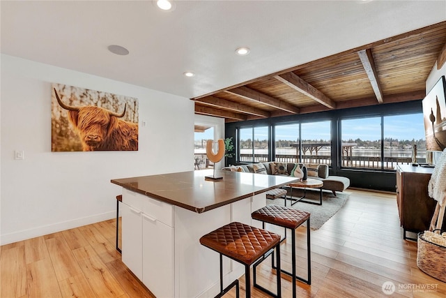 108 E Lake Stevens Rd, Lake Stevens, WA 98258 - kitchen with white cabinetry, a wooden ceiling with exposed beams, a breakfast bar area, light wood-style flooring, and recessed lighting