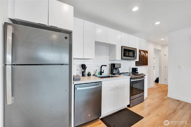 108 E Lake Stevens Rd, Lake Stevens, WA 98258 - kitchen with stainless steel appliances, white cabinets, light wood-style flooring, recessed lighting, and light countertops