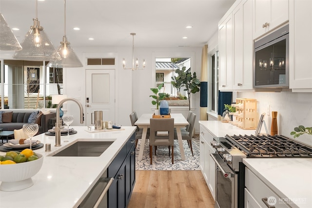 13434 HS3 NE 112th Pl, Redmond, WA 98052 - kitchen with stainless steel appliances, a sink, light wood-style flooring, recessed lighting, and light countertops