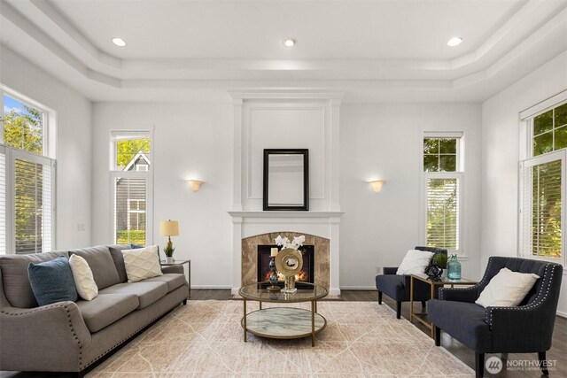 7645 Dogwood Ln SE, Snoqualmie, WA 98065 - living room featuring a tray ceiling, wood finished floors, a premium fireplace, and recessed lighting