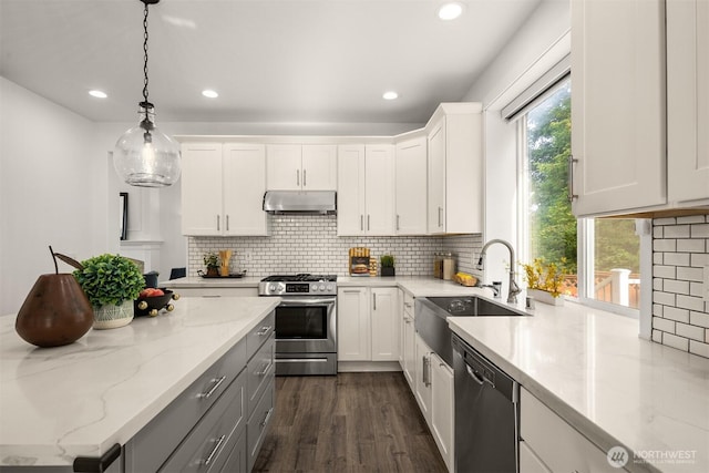 7645 Dogwood Ln SE, Snoqualmie, WA 98065 - kitchen featuring under cabinet range hood, appliances with stainless steel finishes, white cabinets, recessed lighting, and tasteful backsplash
