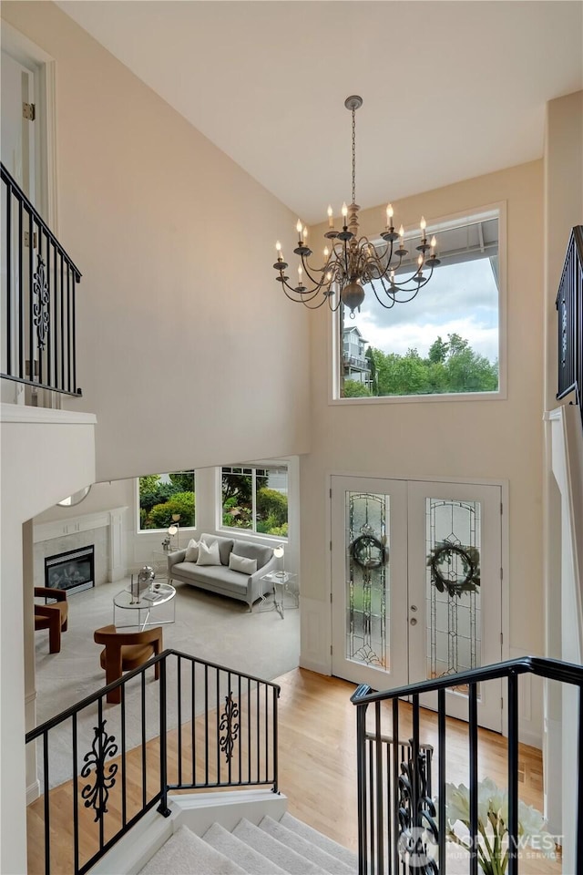 8228 NE 187th Way, Kenmore, WA 98028 - foyer with a high ceiling, a chandelier, wood finished floors, stairs, and a glass covered fireplace