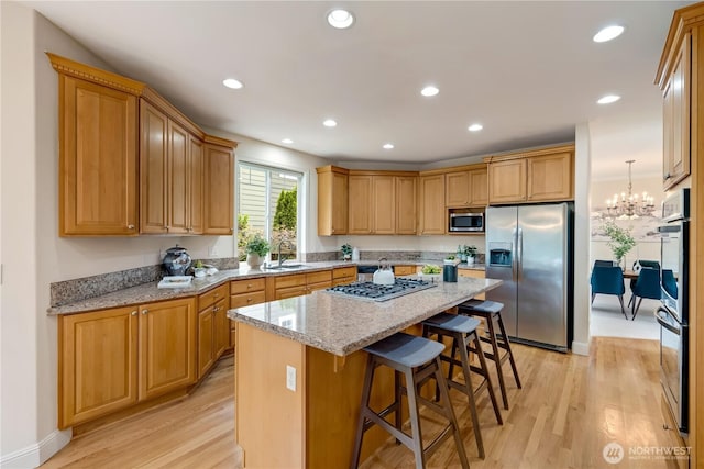 8228 NE 187th Way, Kenmore, WA 98028 - kitchen with stainless steel appliances, light wood-style floors, a center island, a breakfast bar area, and recessed lighting