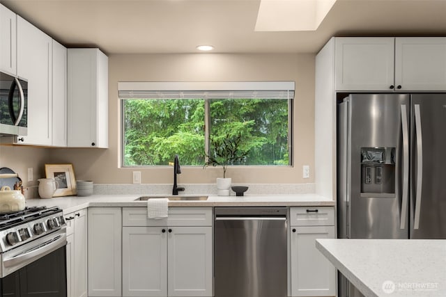 539 129th Ave SE, Bellevue, WA 98005 - kitchen with appliances with stainless steel finishes, plenty of natural light, a skylight, white cabinets, and recessed lighting
