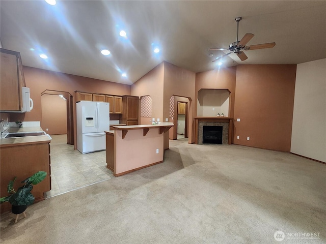 8318 55th Ave SE, Olympia, WA 98513 - kitchen with white appliances, a breakfast bar area, a ceiling fan, light colored carpet, and a peninsula