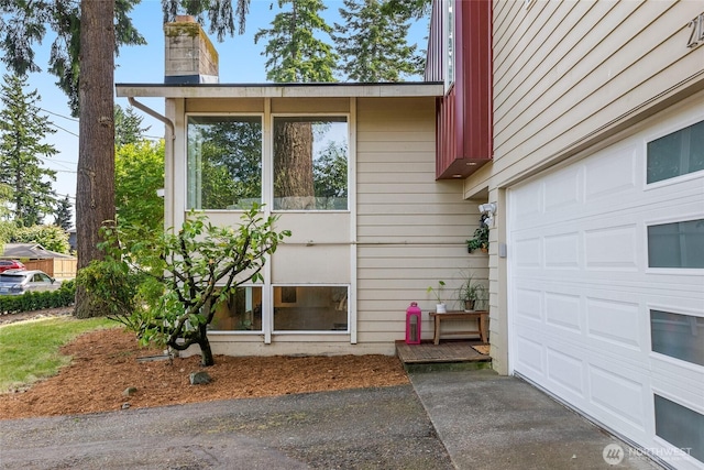 2127 170th Ave NE, Bellevue, WA 98008 - property entrance with a garage, asphalt driveway, and a chimney