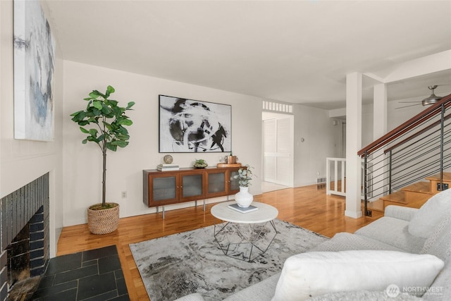 2127 170th Ave NE, Bellevue, WA 98008 - living area with a brick fireplace, stairway, wood finished floors, and a ceiling fan