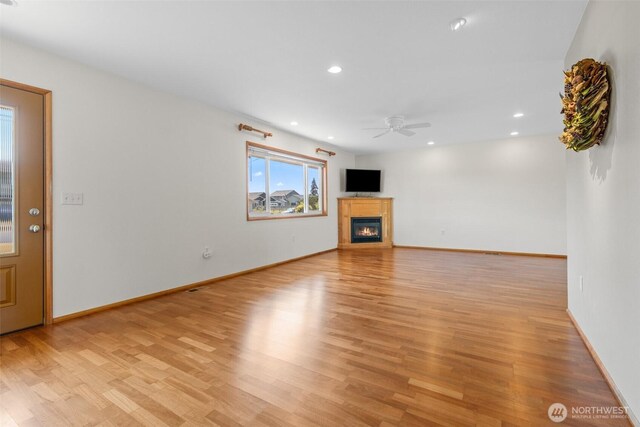1103 Fieldcrest Ave, Centralia, WA 98531 - unfurnished living room featuring a ceiling fan, light wood-style flooring, a glass covered fireplace, and recessed lighting