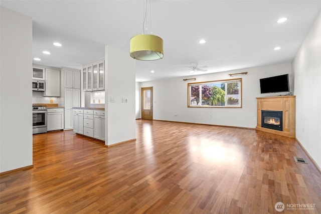 1103 Fieldcrest Ave, Centralia, WA 98531 - unfurnished living room with light wood finished floors, a glass covered fireplace, recessed lighting, and ceiling fan