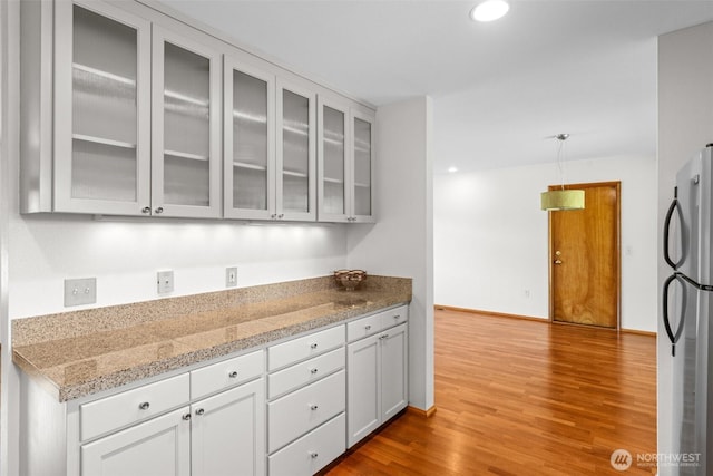 1103 Fieldcrest Ave, Centralia, WA 98531 - kitchen featuring freestanding refrigerator, wood finished floors, glass insert cabinets, recessed lighting, and white cabinets