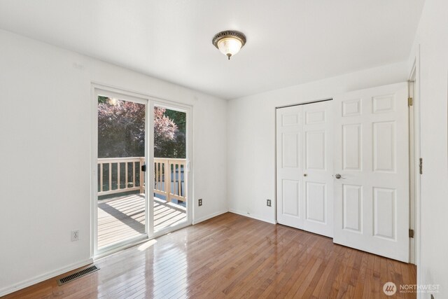 3028 124th St SE, Everett, WA 98208 - unfurnished bedroom featuring access to exterior, hardwood / wood-style floors, and a closet