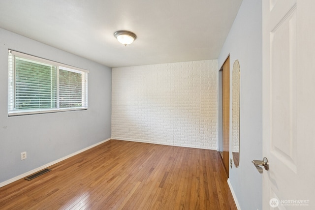 3028 124th St SE, Everett, WA 98208 - spare room with wood-type flooring and brick wall