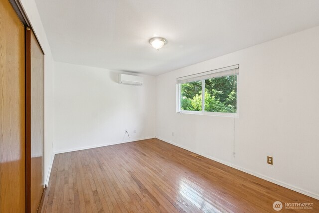 3028 124th St SE, Everett, WA 98208 - unfurnished bedroom with a wall mounted AC, light wood finished floors, and a closet