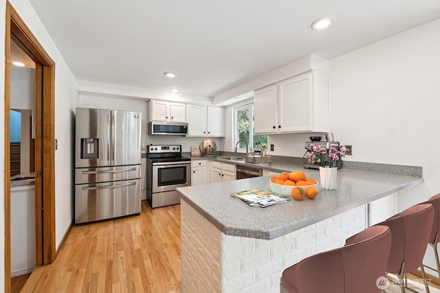 3028 124th St SE, Everett, WA 98208 - kitchen featuring stainless steel appliances, light wood-type flooring, a peninsula, white cabinetry, and recessed lighting