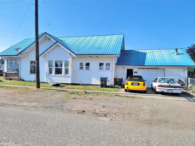 1004 N Tower Ave, Centralia, WA 98531 - view of front facade featuring a garage, metal roof, and asphalt driveway