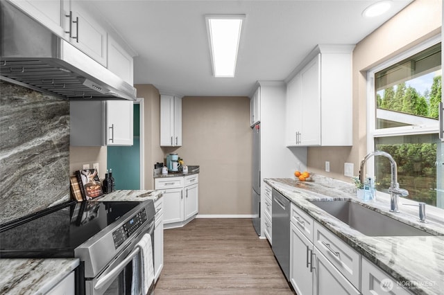 3910 Westpark Ct NW, Olympia, WA 98502 - kitchen featuring stainless steel appliances, under cabinet range hood, light wood-style floors, white cabinets, and light stone countertops