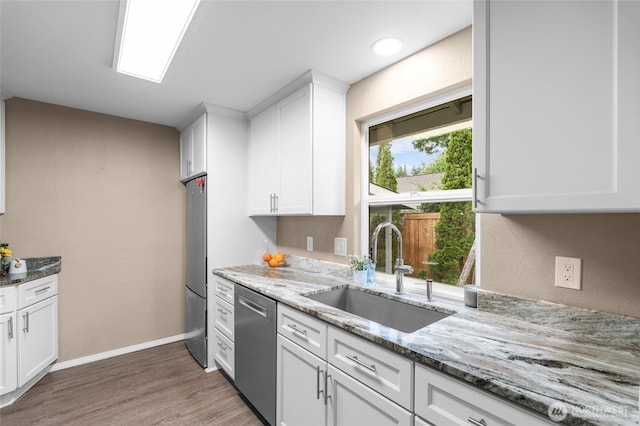 3910 Westpark Ct NW, Olympia, WA 98502 - kitchen with stainless steel appliances, white cabinets, light wood-style floors, and light stone countertops