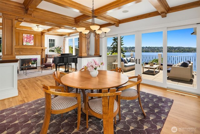 8260 Avalon Dr, Mercer Island, WA 98040 - dining space with light wood-style floors, beam ceiling, a water view, a chandelier, and coffered ceiling