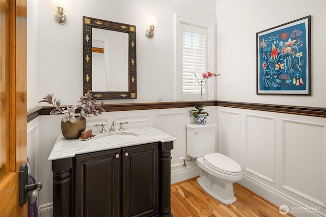 8260 Avalon Dr, Mercer Island, WA 98040 - half bath featuring a decorative wall, toilet, vanity, wood finished floors, and a wainscoted wall