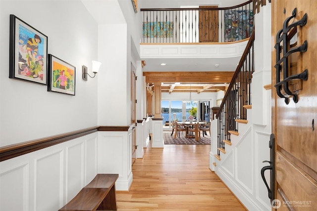 8260 Avalon Dr, Mercer Island, WA 98040 - entryway featuring light wood-style floors, stairs, beamed ceiling, a decorative wall, and wainscoting