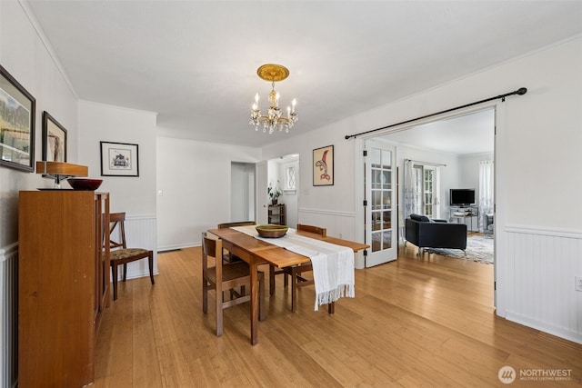 4919 N 31st St, Tacoma, WA 98407 - dining space featuring light wood-style floors, wainscoting, a chandelier, and french doors