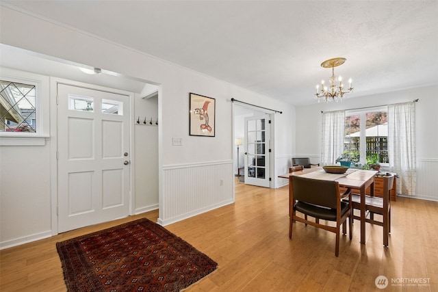 4919 N 31st St, Tacoma, WA 98407 - dining area featuring a chandelier, light wood finished floors, wainscoting, and french doors