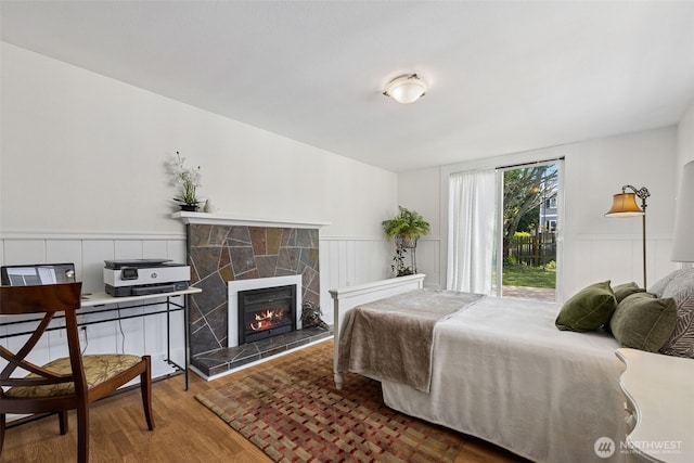 4919 N 31st St, Tacoma, WA 98407 - bedroom with wainscoting, a fireplace, wood finished floors, access to outside, and a decorative wall