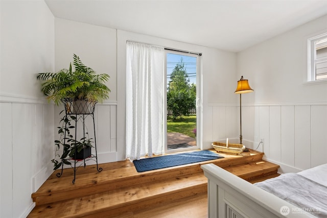 4919 N 31st St, Tacoma, WA 98407 - bedroom with a decorative wall, wainscoting, access to exterior, and wood finished floors