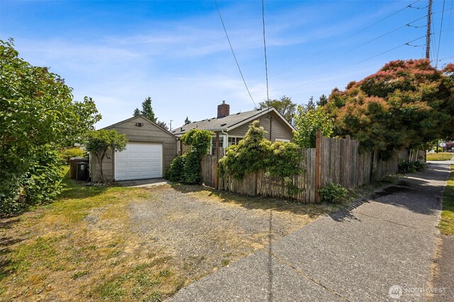 4919 N 31st St, Tacoma, WA 98407 - view of home's exterior with driveway, a detached garage, and an outbuilding