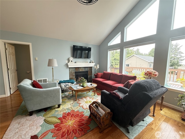 762 Evergreen Ave SE, Ocean Shores, WA 98569 - living room with wood finished floors, a tiled fireplace, and high vaulted ceiling