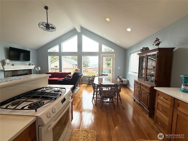 762 Evergreen Ave SE, Ocean Shores, WA 98569 - kitchen with white range with gas cooktop, hardwood / wood-style flooring, plenty of natural light, a fireplace, and recessed lighting