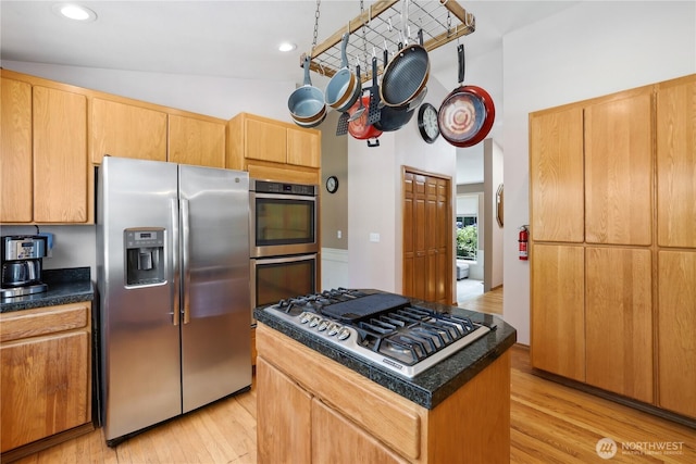 1612 SW 304th St, Federal Way, WA 98023 - kitchen with stainless steel appliances, light wood finished floors, dark countertops, a kitchen island, and a towering ceiling