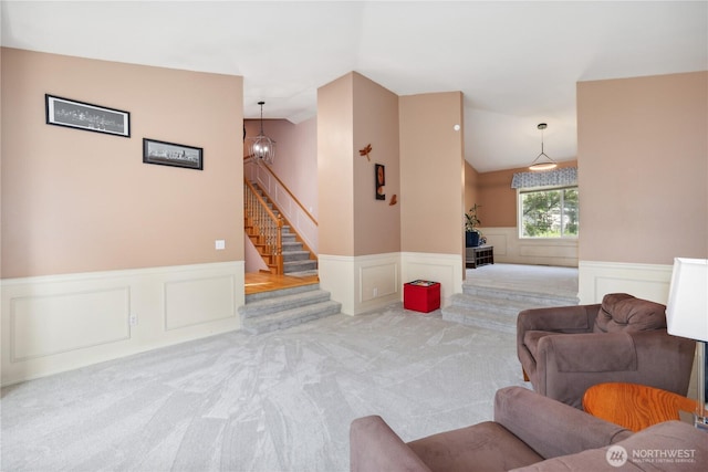 1612 SW 304th St, Federal Way, WA 98023 - carpeted living room featuring a wainscoted wall, a decorative wall, vaulted ceiling, stairway, and a chandelier