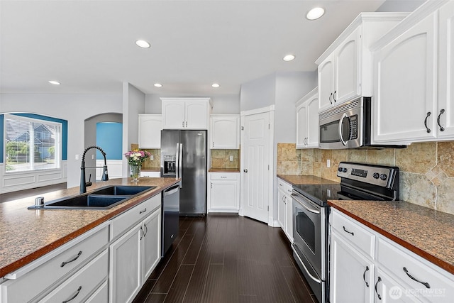 1208 Goldfinch Ave SW, Orting, WA 98360 - kitchen featuring appliances with stainless steel finishes, white cabinetry, recessed lighting, backsplash, and dark countertops