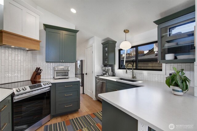 2219 Fairview Ave E Unit 5, Seattle, WA 98102 - kitchen with appliances with stainless steel finishes, a sink, light countertops, light wood finished floors, and recessed lighting