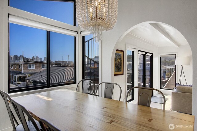 2219 Fairview Ave E Unit 5, Seattle, WA 98102 - dining space featuring arched walkways, a chandelier, and a view of skyline