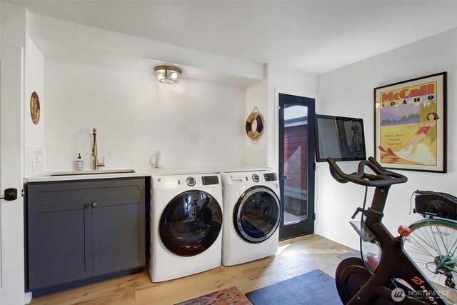 2219 Fairview Ave E Unit 5, Seattle, WA 98102 - washroom featuring washing machine and dryer, light wood finished floors, cabinet space, and wet bar