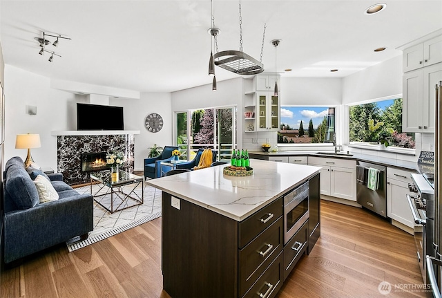 11115 NE 95th St, Kirkland, WA 98033 - kitchen with stainless steel appliances, open floor plan, a sink, white cabinets, and wood finished floors
