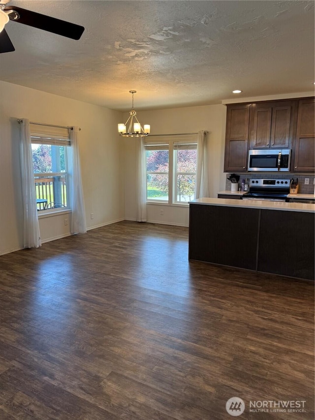 2101 S 324th St Unit 107, Federal Way, WA 98003 - kitchen featuring stainless steel appliances, dark wood-style floors, a chandelier, plenty of natural light, and a textured ceiling