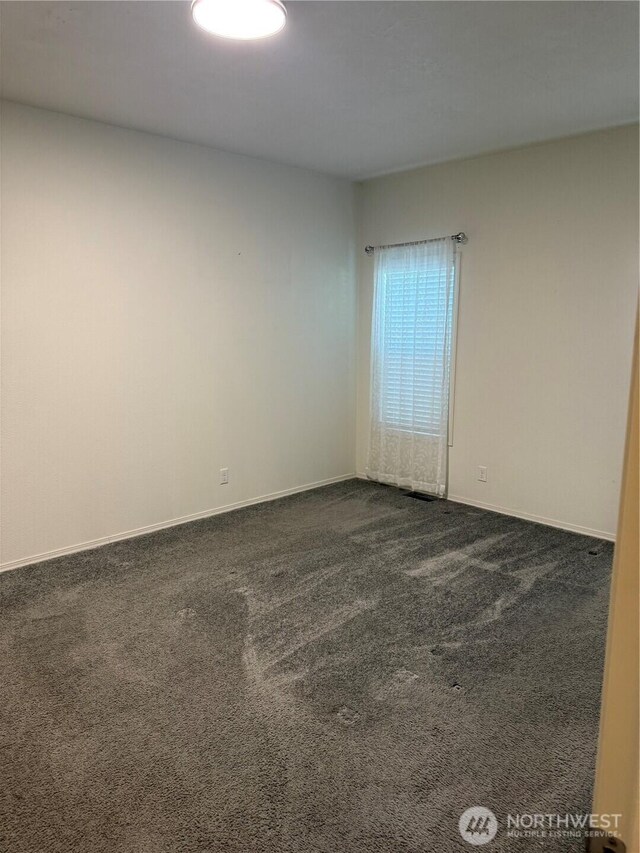 2101 S 324th St Unit 107, Federal Way, WA 98003 - unfurnished room featuring dark colored carpet and baseboards