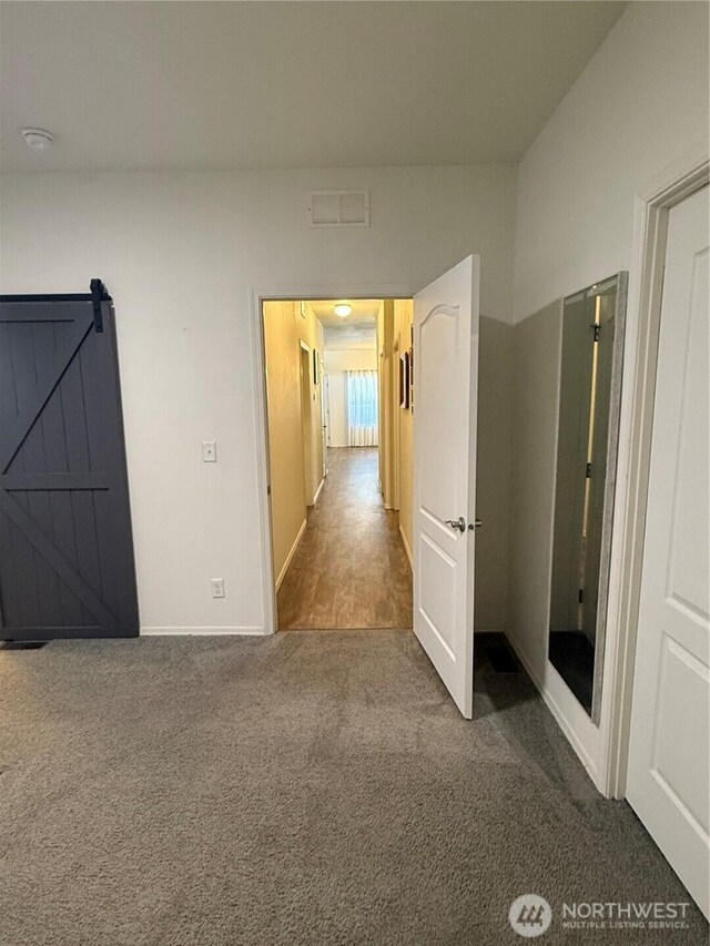 2101 S 324th St Unit 107, Federal Way, WA 98003 - hall featuring carpet floors, baseboards, and a barn door